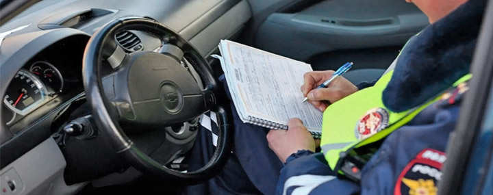 Полицейский выписыват штраф водителю